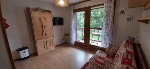 salon z kanapą i dużym oknem w obiekcie Un havre de paix aux pieds des chemins de montagne w mieście Contamines-Montjoie
