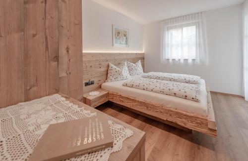 a bedroom with two beds and a window at Ortnerhof in San Giovanni in Val Aurina
