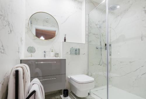 ein Bad mit einer Dusche, einem WC und einem Waschbecken in der Unterkunft Apartamentos La Xiuca Playa in Gijón