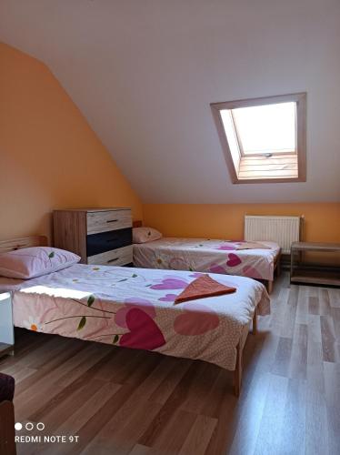 three beds in a room with a window at Lapegles 2 in Ludza