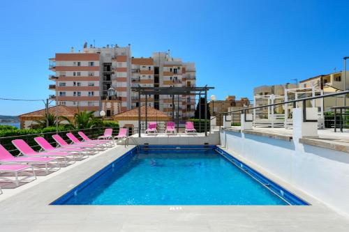 - une piscine avec des chaises longues dans un bâtiment dans l'établissement Aparthotel Vibra Sanan - Adults only, à Sant Antoni de Portmany