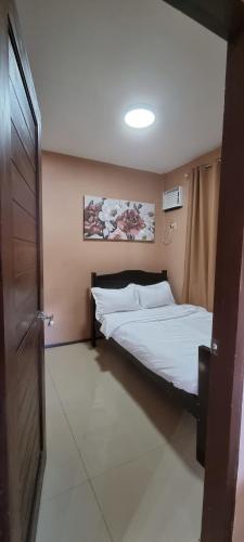 ein Schlafzimmer mit einem Bett und einer Tür darin in der Unterkunft Tagoloan 'Boutique' Apartments in Aplaya