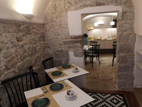 a dining room with two tables and a kitchen at Casa Pagiò in Bosa