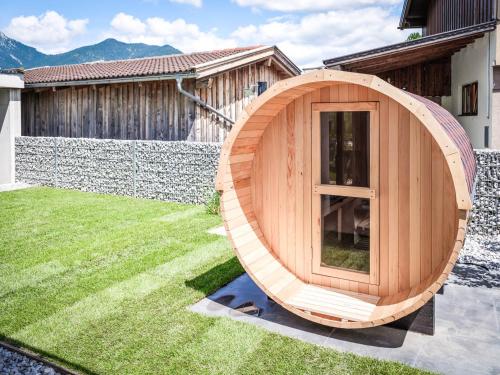 a wooden circular sauna in a yard with a house at Apartments Frauensee in Reutte