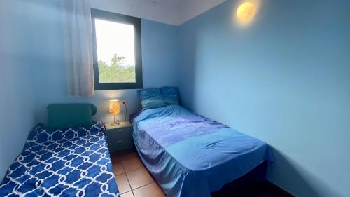 a blue bedroom with a bed and a window at Bonito Dúplex Msj 83 in Calafat