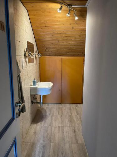 a bathroom with a sink and a wooden ceiling at Giulias Budget Haus in Reutte