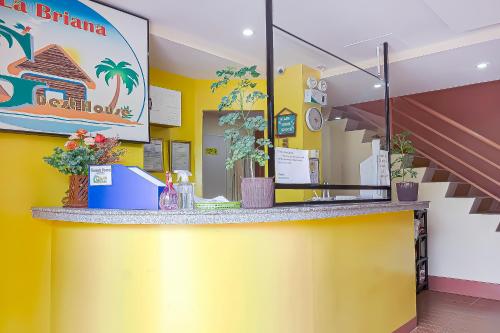 a restaurant with a yellow counter with plants on it at RedDoorz at La Briana Guest House Santa Fe, Bantayan Cebu in Bantayan Island