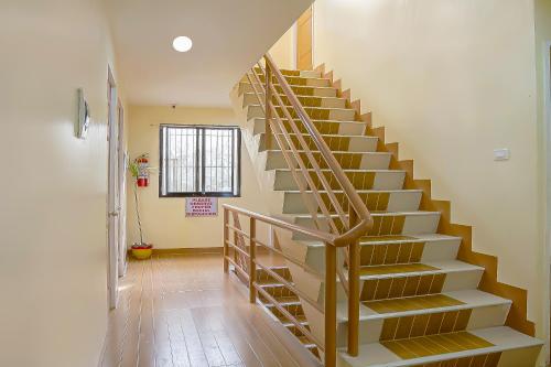 a staircase in a home with wooden treads at RedDoorz at La Briana Guest House Santa Fe, Bantayan Cebu in Bantayan Island