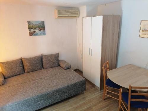um pequeno quarto com um sofá e uma mesa em Apartman Milica em Golubić