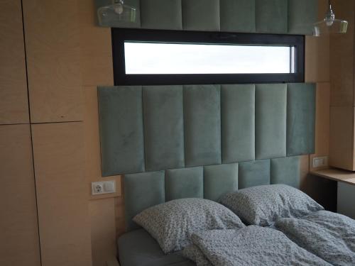 a bedroom with a bed with a window above it at Steigen Lodge Tiny house in Steigen