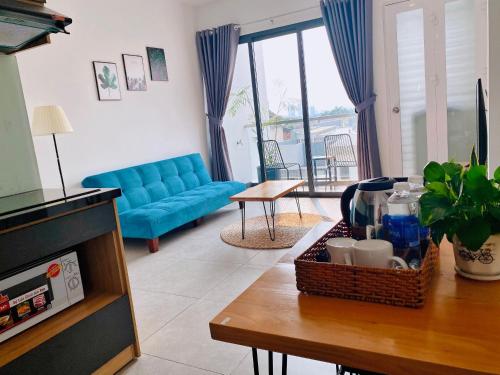 a living room with a blue couch and a table at Arista in Ho Chi Minh City