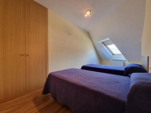 een slaapkamer op zolder met 2 bedden en een trap bij Foz Playa Rapadoira - 2 dormitorios in Foz