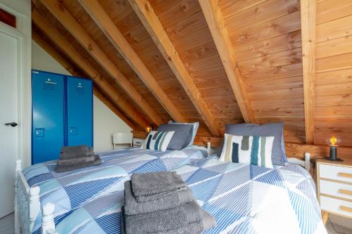 1 dormitorio con 2 camas y techo de madera en Langevliet 4 - Klaver 4 Callantsoog, en Callantsoog