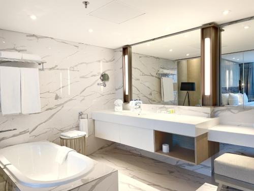 a bathroom with a sink and a toilet and a mirror at Swiss-Belhotel Solo in Solo