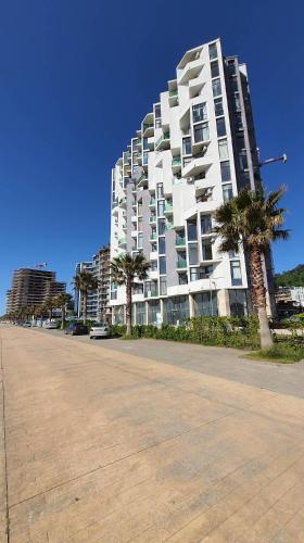 ゴニオにあるGonio Seaside Residenceのヤシの木が前に立つ大きな白い建物
