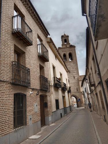 an alley with a building and a clock tower at Apartamentos Turísticos La Casa Grande in Arévalo