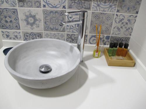 a white sink in a bathroom with blue and white tiles at Apartamentos Turísticos La Casa Grande in Arévalo