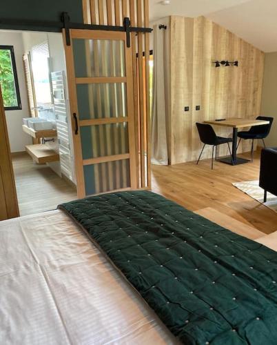 une chambre avec un lit et une table avec des chaises dans l'établissement Lodge La Courrège, à Larché