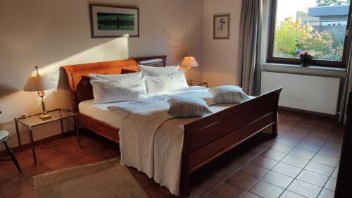 a bedroom with a large bed and a window at Ferienhaus an der Förde in Flensburg