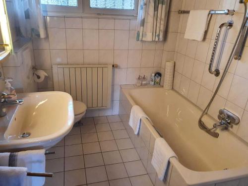 a bathroom with a tub and a toilet and a sink at Ferienhaus an der Förde in Flensburg