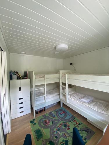 a room with two bunk beds and a rug at Voss, Øvre Tråstølen in Skulestadmo