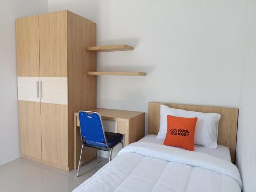 1 dormitorio con cama, escritorio y silla azul en KoolKost Female Syariah near Universitas Ahmad Dahlan Kampus 3 - Minimum Stay 30 Nights, en Timuran