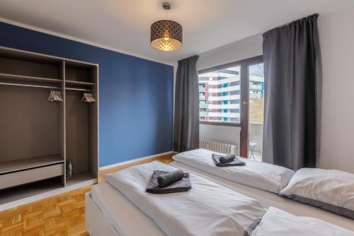 a bedroom with two beds and a large window at Glück Auf Appartements Kammerstr. Duisburg in Duisburg