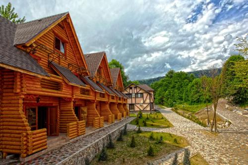 a log cabin building with a mountain in the background at Recreation Complex Uzhanski Kupeli in Volosyanka