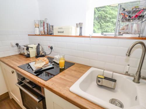 uma cozinha com um lavatório e uma bancada em The Old Stables em Chippenham