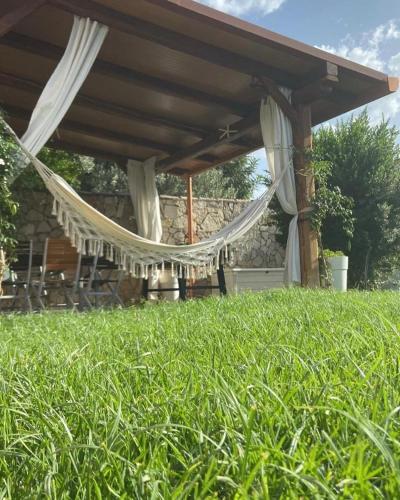 a porch with a hammock in a field of grass at B&B Il Sentiero in San Sperate