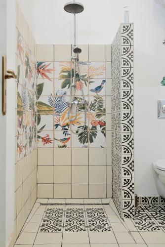 a bathroom with a shower with a tile wall at Angel holiday appartman in Szentantalfa