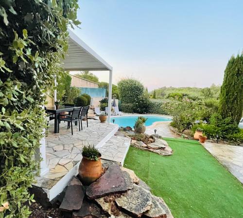 un jardin avec une terrasse et une piscine dans l'établissement Villa privée avec piscine, à Valescure