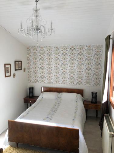 ein Schlafzimmer mit einem großen Bett und einem Kronleuchter in der Unterkunft Holli cottage - Charming 2 bedrooms with terrace. in Saint-Avit-Rivière