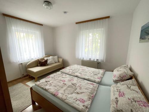 a small bedroom with two beds and a couch at Ferienwohnungen Gmeiner in Bad Endorf