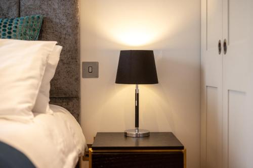 a lamp on a night stand next to a bed at Bath Circle in Bath