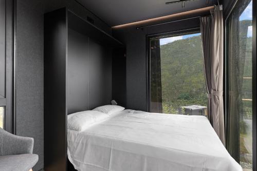 sypialnia z łóżkiem i dużym oknem w obiekcie Sogndal Fjordpanorama - Studio Cabins With View w mieście Sogndal