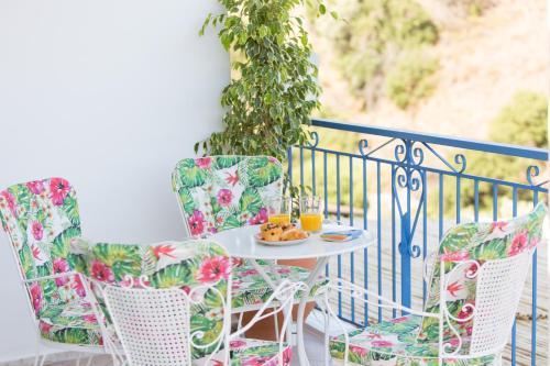 a table with chairs and a plate of food on a balcony at ALTHEA - cozy with spacious terrace views in Galatas