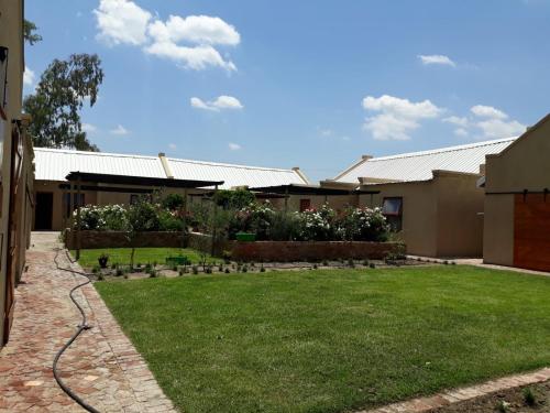 a house with a lawn in front of a yard at Studios @ Delver in Parys