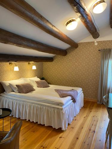 a bedroom with a large bed with white sheets at Bredsjö Gamla Herrgård White Dream Mansion in Hällefors
