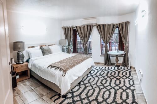 een slaapkamer met een groot bed en een tapijt bij Gold Pot Stay a 5 bedroom House in Pretoria