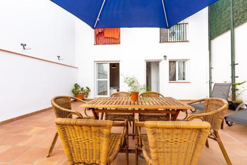 una mesa de madera y sillas con una sombrilla azul en Casa sol, en Vélez-Málaga