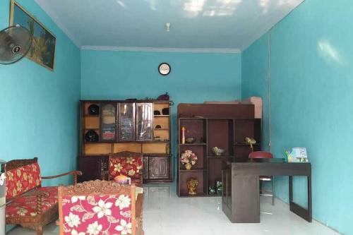 a living room with a table and a blue wall at RedDoorz Syariah near Stasiun Pekalongan 3 in Pekalongan
