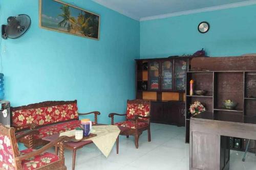 a living room with a couch and chairs and a table at RedDoorz Syariah near Stasiun Pekalongan 3 in Pekalongan