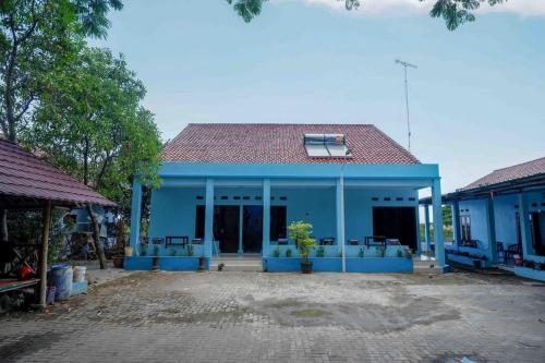 a blue house with a red roof at RedDoorz Syariah near Stasiun Pekalongan 3 in Pekalongan