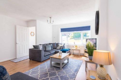 a living room with a couch and a table at Modern three bedroom home in Castle Donington in Castle Donington
