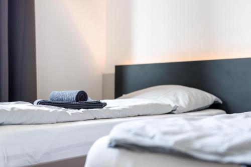 two beds with white sheets and a hat on them at Glück Auf Appartements Düppelstraße in Oberhausen