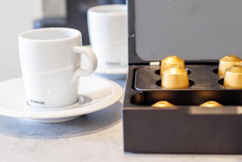 a coffee mug and a cup on a table at Glück Auf Appartements Düppelstraße in Oberhausen