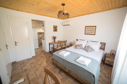 um quarto com uma cama e um tecto de madeira em ALTHEA - cozy with spacious terrace views em Galatas