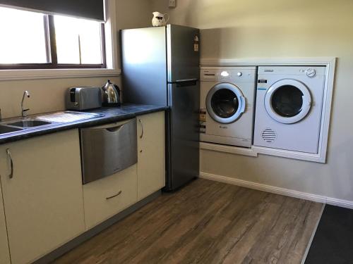 una cucina con frigorifero, lavatrice e asciugatrice di Mudgee Apartments on Church Street a Mudgee