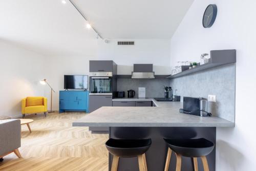a kitchen with a counter and chairs in a room at Glück Auf Appartements Düppelstraße in Oberhausen